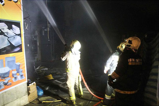 پاساژ لوازم خانگی شوش در آتش سوخت/ عملیات شبانه آتش نشانان برای نجات نگهبان+ تصاویر