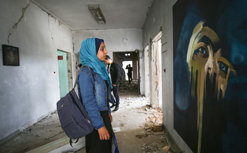 فنان فلسطيني يبدع في رسم لوحات على بقايا جدران بنايات غزة المدمرة