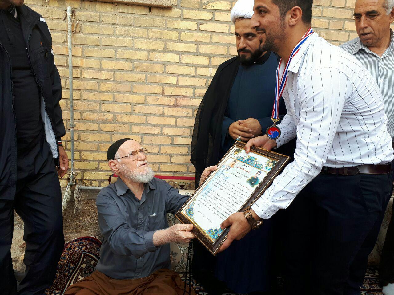 مدال طلا قهرمان آسیا بر گردن پدر شهید تاج بخش