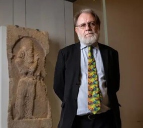 جان سیمپسون کارشناس بخش خاور نزدیک موزه بریتانیا در کنار سنگ نگاره ساسانی